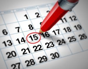 Setting an important date on a calendar with a red pencil marking a day of the month representing organizing time and schedule.